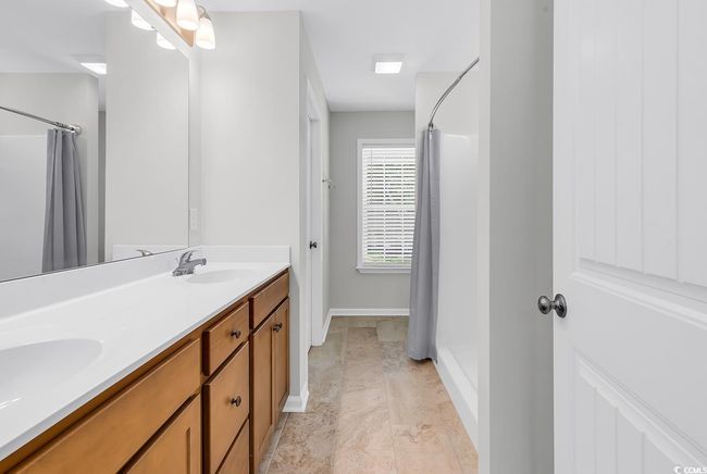 Bathroom featuring curtained shower, double vanity, and baseboards | Image 22