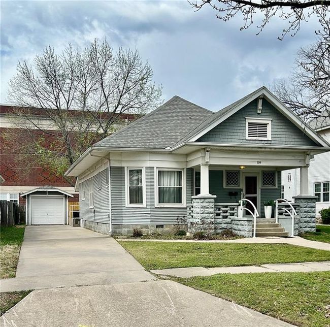 View of front of home with an outbuilding, roof with shingles, driveway, a detached garage, and a porch | Image 4