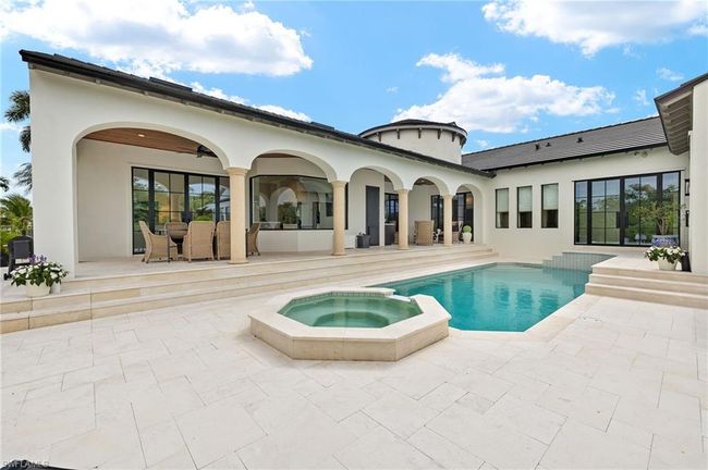 Rear view of property with stucco siding, a patio area, and a pool with connected hot tub | Image 43