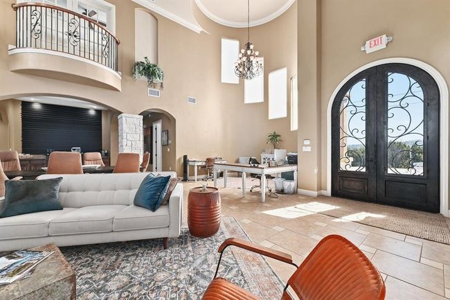 Entrance foyer featuring crown molding, french doors, an inviting chandelier, arched walkways, and visible vents | Image 6