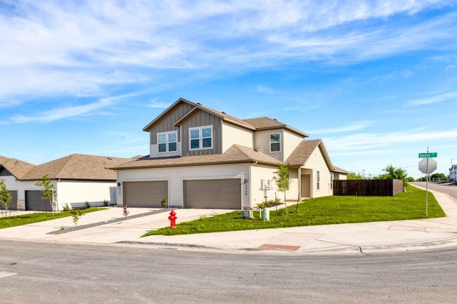 View of front facade with a garage, fence, driveway, a front lawn, and board and batten siding | Image 6