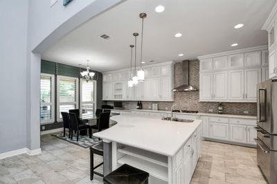 One of the many highlights of the home is the kitchen with ample storage space provided by the many upgraded cabinets the run the length of the counters as well as the large quartz-topped kitchen island. | Image 2