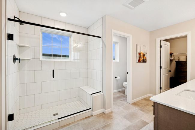This beautifully designed bathroom offers dual sinks, a walk-in tiled shower, and a separate water closet—combining style and functionality for a spa-like experience every day. | Image 28