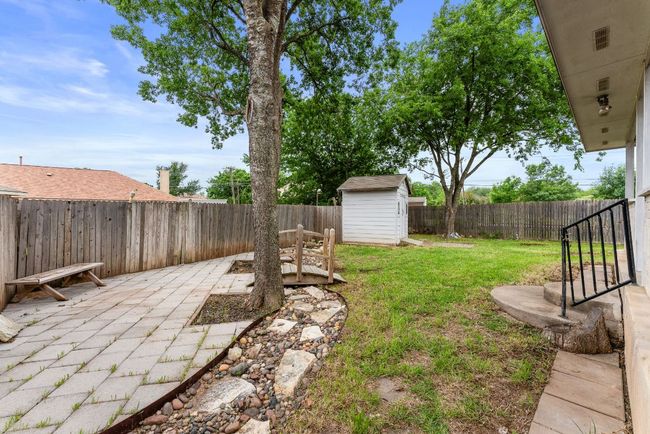 View of yard featuring a patio, a fenced backyard, a shed, and an outbuilding | Image 33