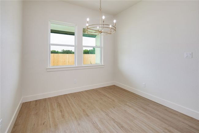Unfurnished room featuring a chandelier, wood finished floors, and baseboards | Image 15