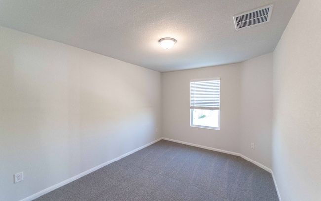 Empty room with dark colored carpet and a textured ceiling | Image 14