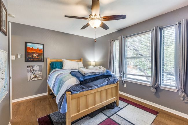 Bedroom featuring multiple windows, wood finished floors, and baseboards | Image 16