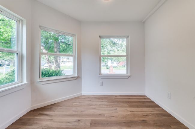 Empty room with light wood finished floors, baseboards, and a wealth of natural light | Image 14
