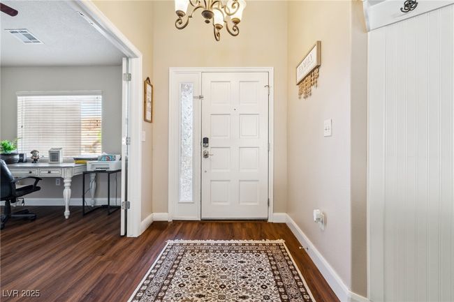 Entrance foyer with dark wood-style floors, a chandelier, and baseboards | Image 7