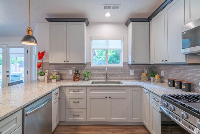 Kitchen with decorative light fixtures, sink, stainless steel appliances, and tasteful backsplash | Image 32