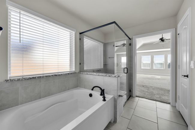 Primary bath with tile patterned flooring, a healthy amount of sunlight, and vaulted ceiling | Image 24