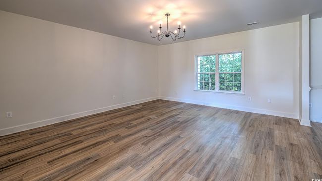 Unfurnished room with a chandelier and wood finished floors | Image 12