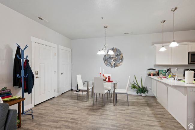 Dining space with a chandelier and light wood-style floors | Image 6