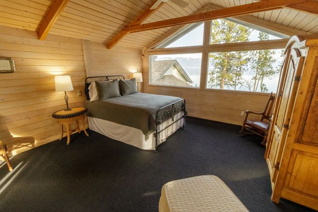 Carpeted bedroom featuring wooden ceiling, lofted ceiling with beams, wooden walls, and ceiling fan | Image 39