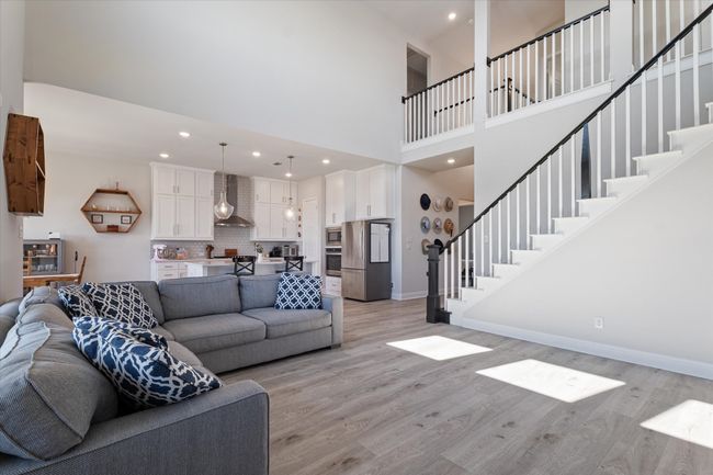 Living area with a towering ceiling, stairway, light wood-style flooring, baseboards, and recessed lighting | Image 17