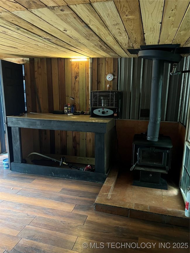 Bar area featuring a wood stove, hardwood / wood-style flooring, and wood walls | Image 28
