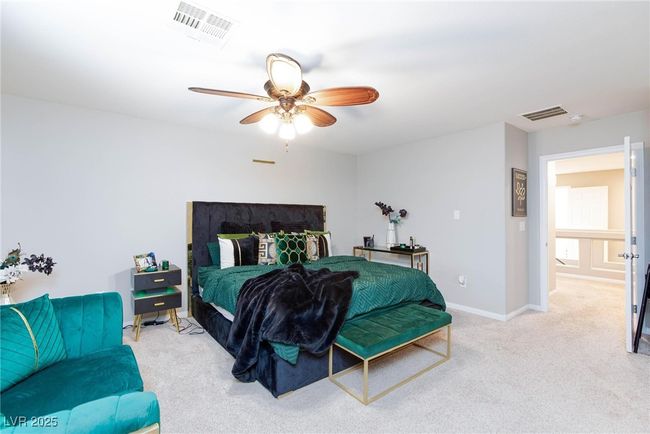 Carpeted bedroom featuring baseboards, visible vents, and ceiling fan | Image 23