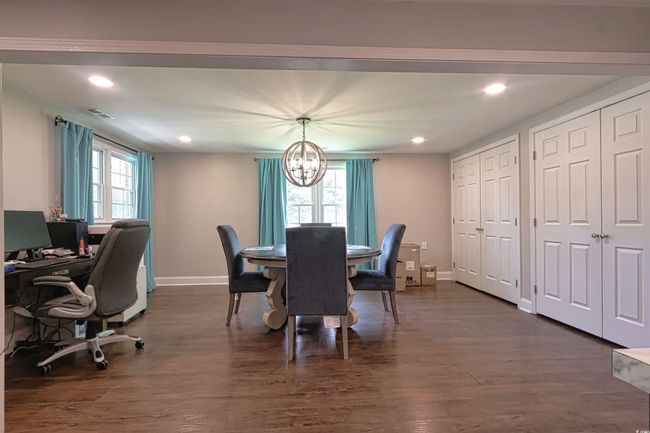 Dining area with a chandelier, dark wood finished floors, and recessed lighting | Image 15