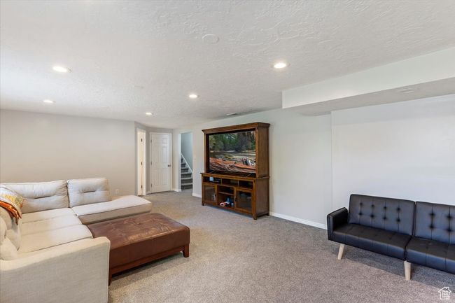 Carpeted living room with recessed lighting, baseboards, stairs, and a textured ceiling | Image 19