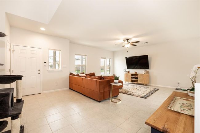 Living area with a ceiling fan, recessed lighting, and light tile patterned flooring | Image 8