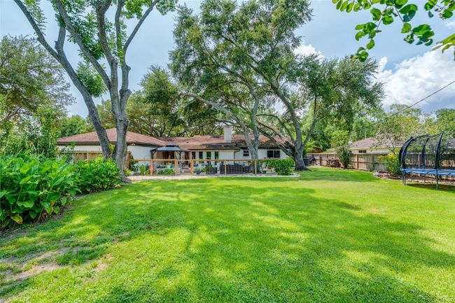 Enjoy the privacy of a double fenced backyard, featuring a lush green lawn and mature trees, offering a peaceful and serene outdoor space. | Image 18