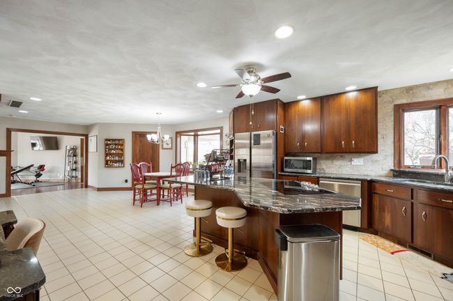 kitchen with a sink, tasteful backsplash, a center island, stainless steel appliances, and light tile patterned floors | Image 16