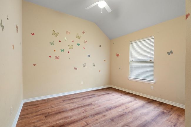 Unfurnished room with a ceiling fan, light wood finished floors, and lofted ceiling | Image 32