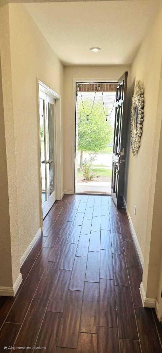 Foyer featuring healthy amount of natural light, dark wood-type flooring, and a textured wall | Image 4