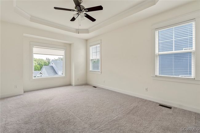 Unfurnished room featuring a tray ceiling, ornamental molding, light colored carpet, and ceiling fan | Image 27