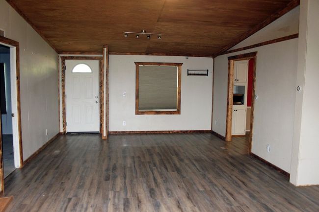 Unfurnished room with wooden ceiling, dark wood-style flooring, baseboards, and lofted ceiling | Image 5