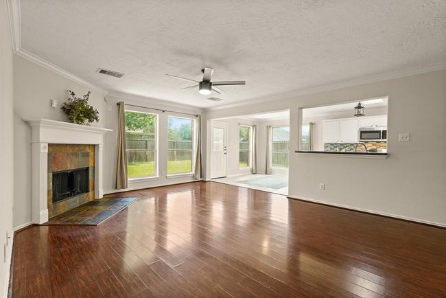 Bright, open living room with seamless views of the backyard and kitchen. | Image 8