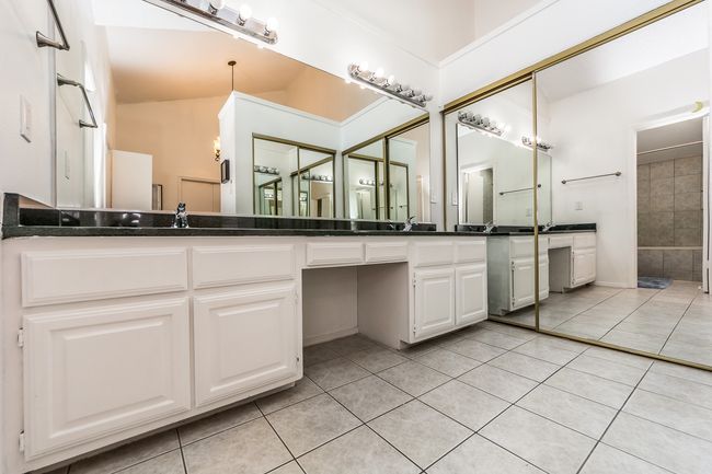 Bathroom with vanity, tile patterned flooring, and a shower | Image 8