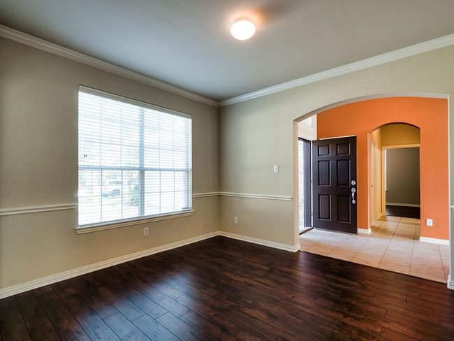 Spare room with arched walkways, hardwood / wood-style floors, ornamental molding, and healthy amount of natural light | Image 11