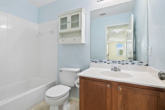 Bathroom with toilet, vanity, shower combination, and tile patterned floors | Image 28