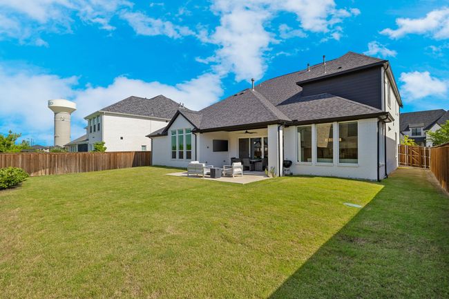 Back of house featuring ceiling fan, roof with shingles, and a patio | Image 36