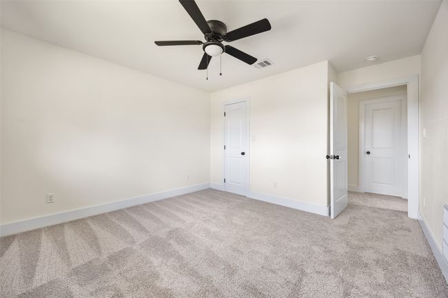Unfurnished bedroom with light colored carpet and ceiling fan | Image 39