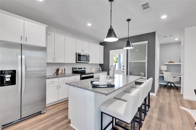 Kitchen with white cabinetry, visible vents, and appliances with stainless steel finishes | Image 7