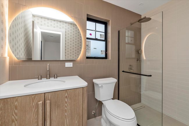 Full bath with tile walls, vanity, a walk in shower, and tasteful backsplash | Image 12