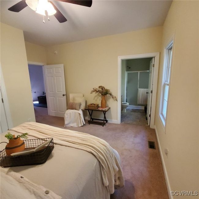 Bedroom with visible vents, connected bathroom, carpet flooring, baseboards, and ceiling fan | Image 27