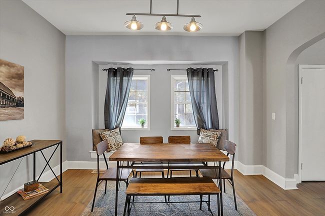 dining space with baseboards, wood finished floors, and arched walkways | Image 13