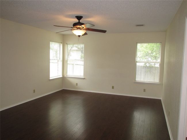 Unfurnished room featuring dark wood-type flooring, a textured ceiling, and ceiling fan | Image 10