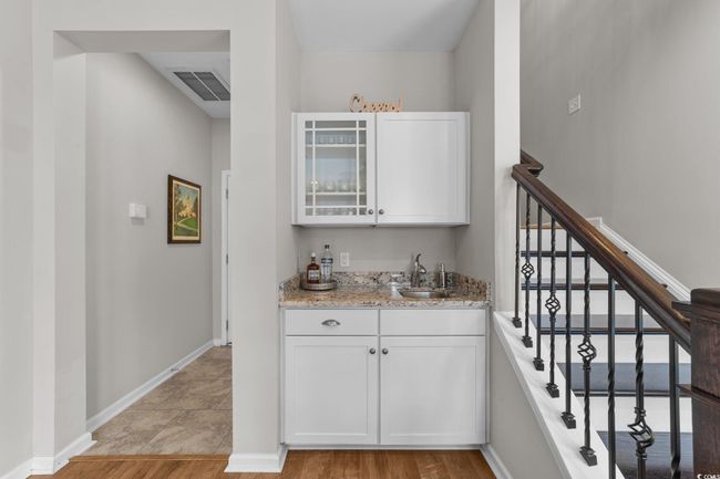 Indoor wet bar featuring baseboards and stairs | Image 23