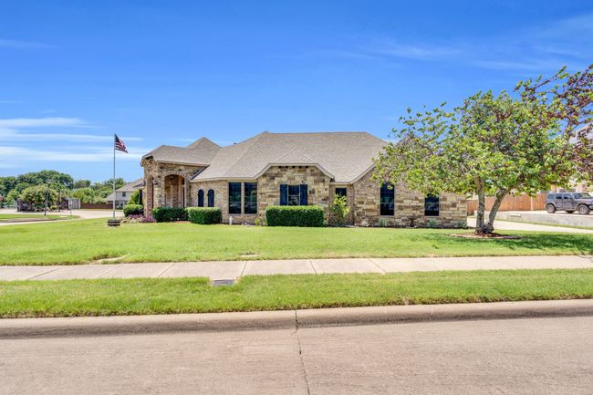 French country inspired facade featuring a front yard, brick siding, and stone siding | Image 38