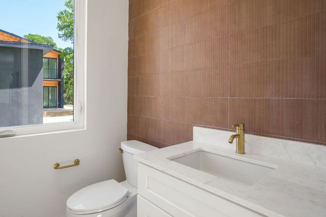 Bathroom featuring toilet, vanity, and tile walls | Image 14