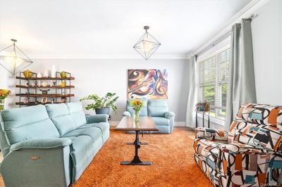 Living room with ornamental molding and a notable chandelier | Image 3