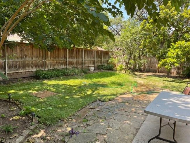 Fenced backyard with a stone patio area | Image 17