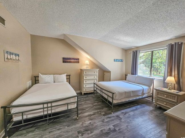 Bedroom with a textured ceiling, wood finished floors, and vaulted ceiling | Image 26