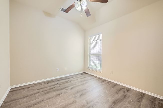 Spare room with a ceiling fan, wood finished floors, and lofted ceiling | Image 19