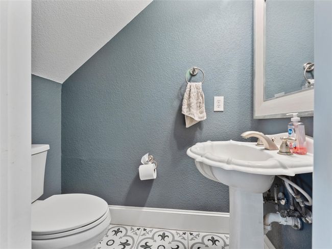 Half bathroom with vaulted ceiling and a textured wall | Image 15