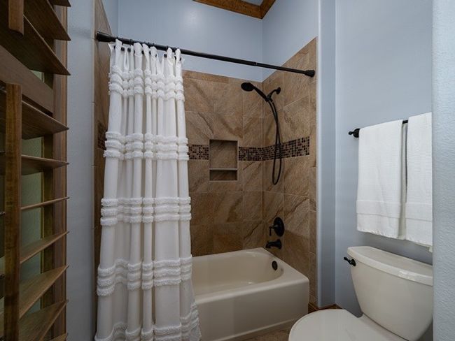 Bathroom featuring toilet and shower / bath combo with shower curtain | Image 27